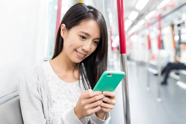 Žena, používání mobilního telefonu ve vlaku — Stock fotografie