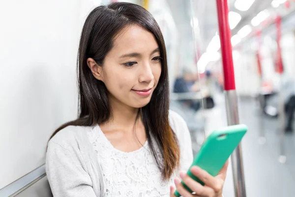 Woman using smartphone inside subway — Stock Photo, Image