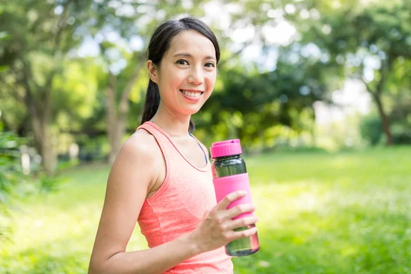 スポーツ女性は、公園で水を飲む — ストック写真