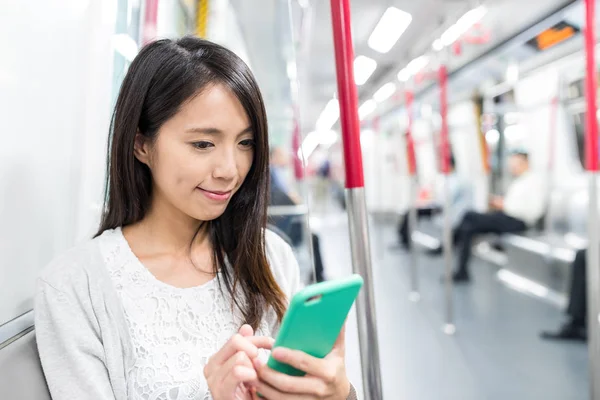 Mulher usando smartphone dentro do metrô — Fotografia de Stock