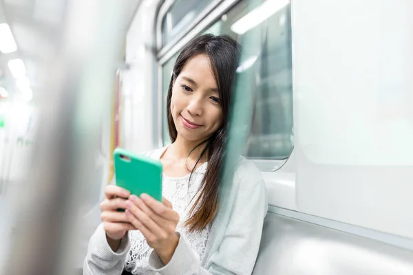 Žena používající mobil uvnitř metra — Stock fotografie
