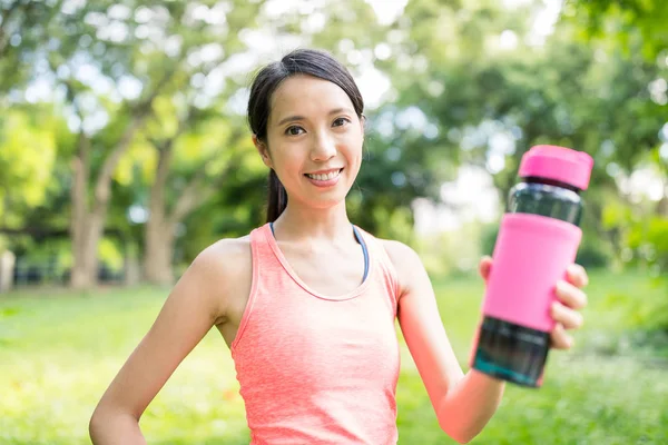 公園内スポーツ女性保持水のボトル — ストック写真