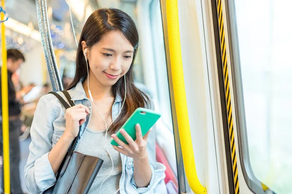Mulher olhando no celular no trem — Fotografia de Stock