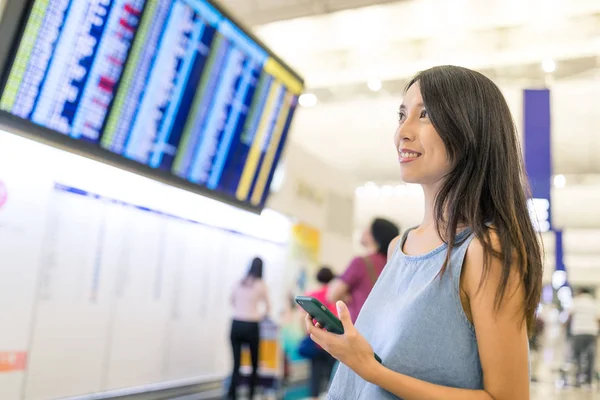 Donna che guarda il numero del volo in aeroporto — Foto Stock