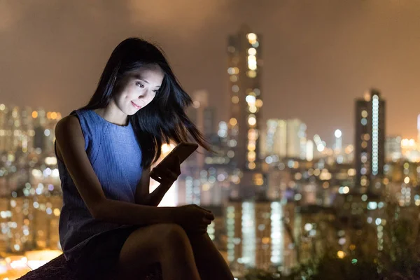 Mulher lendo no celular à noite — Fotografia de Stock