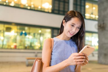 alışveriş merkezinde cep telefonu kullanan kadın