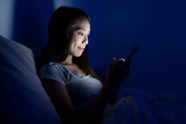 Geceleri cep telefonu kullanan kadın 