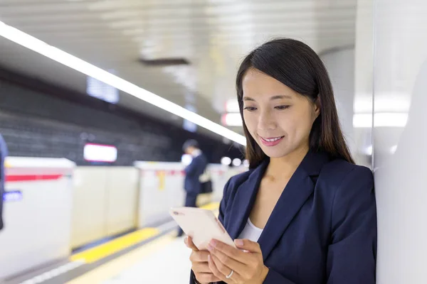 Empresária usando smartphone na plataforma — Fotografia de Stock