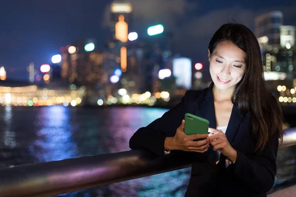 İş kadını cep telefonuyla çalışıyor 