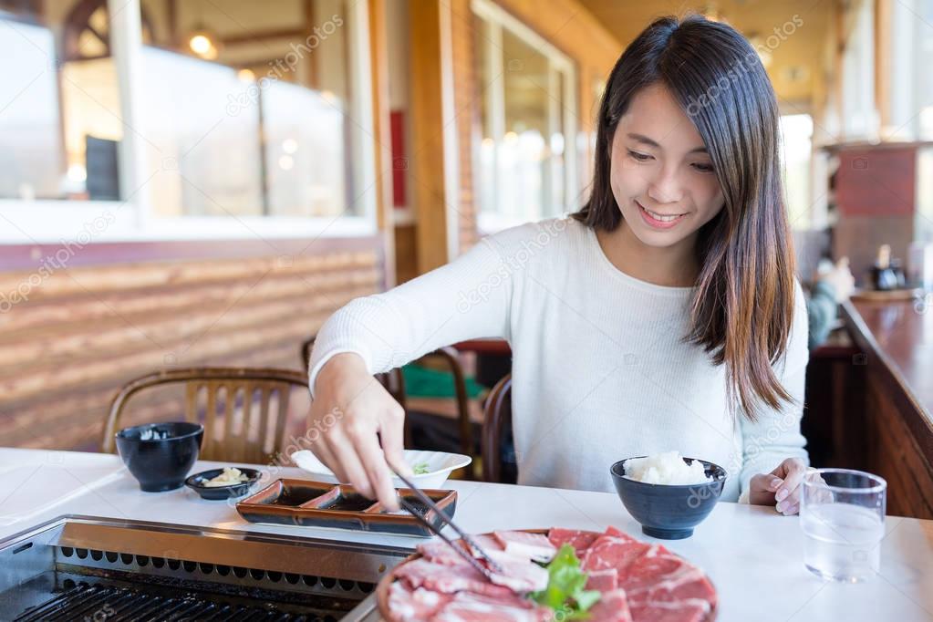Woman enjoy barbecue in japanese restaurant