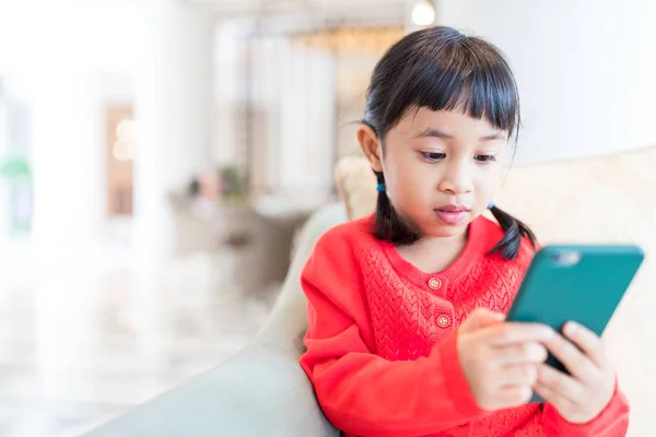 Mała dziewczynka ogląda cellphone — Zdjęcie stockowe