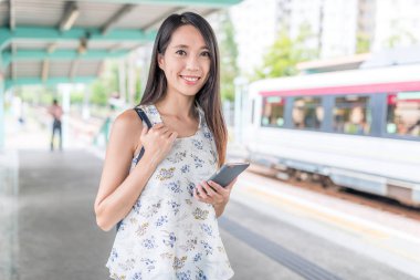 Smartphone tren istasyonu üzerinde tutan kadın