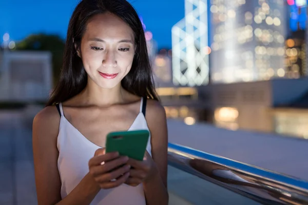Mujer mensajes de texto en el teléfono móvil por la noche —  Fotos de Stock