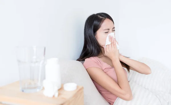 Vrouw op bed niezen — Stockfoto