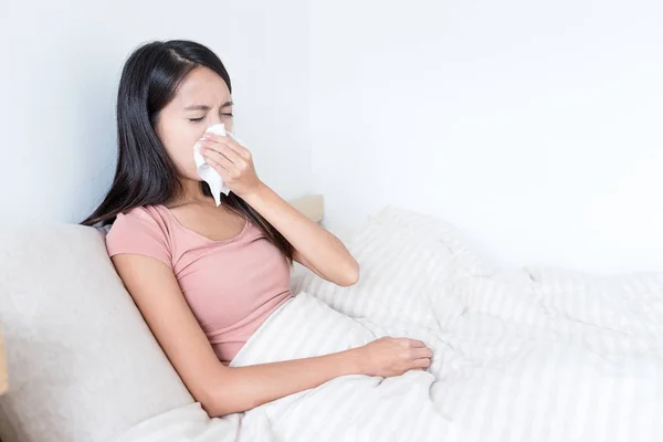 Mujer enferma estornudando en la cama — Foto de Stock