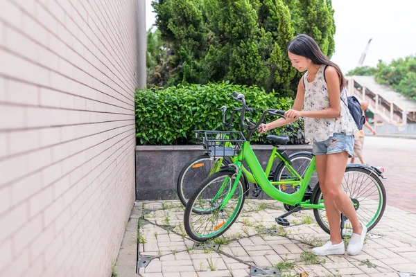 Γυναίκα που προσπαθείτε να χρησιμοποιήσετε το μερίδιο ποδήλατο στην πόλη — Φωτογραφία Αρχείου