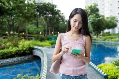 Kadın cep telefonuna bakıyor.