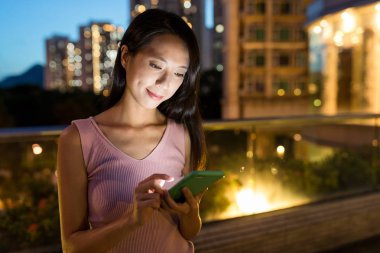 Geceleri cep telefonu kullanan kadın