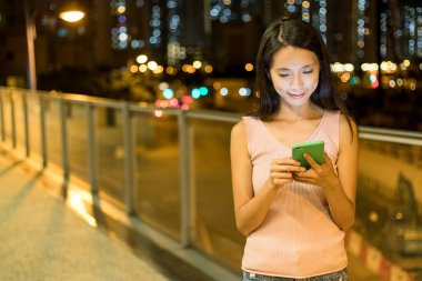 Şehirde akıllı telefon kullanan bir kadın.