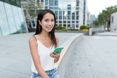Şehirde akıllı telefon kullanan bir kadın.