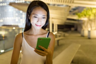 Gece akıllı telefon kullanan bir kadın.