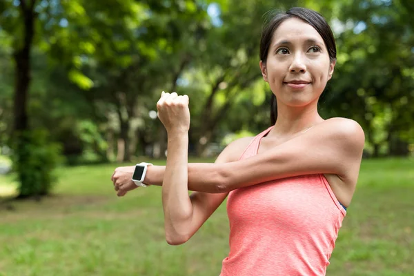 Sport vrouw strekken van de arm in park — Stockfoto