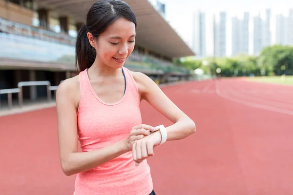 Donna sportiva utilizzando orologio intelligente indossabile — Foto Stock