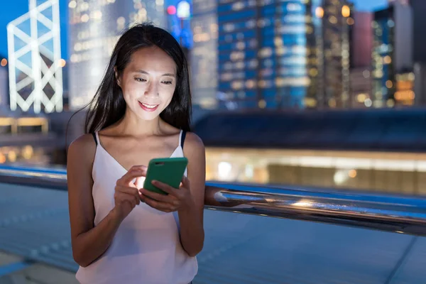 Mulher usando telefone celular à noite — Fotografia de Stock