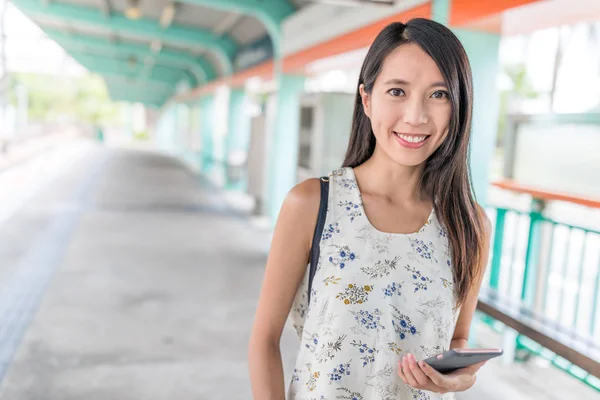 Frau benutzt Smartphone im Bahnhof — Stockfoto