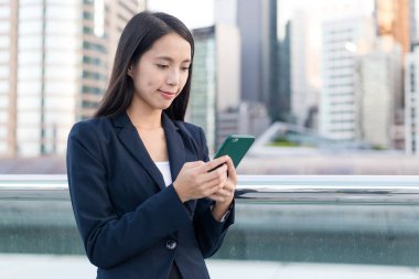 Cep telefonu şehrin üzerinde çalışan iş kadını