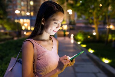 Geceleri cep telefonu kullanan kadın