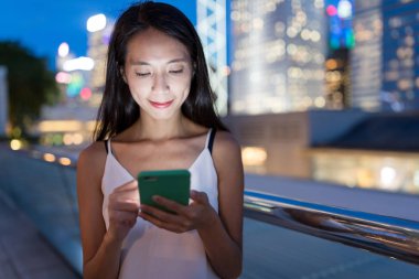 Gece akıllı telefon kullanan bir kadın.
