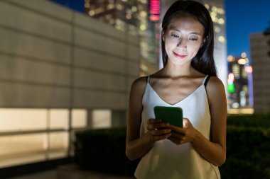 Kadın manifatura gece şehir içinde smartphone