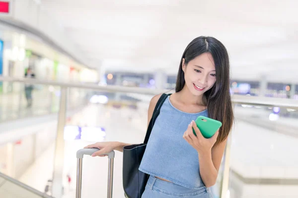 女性は彼女の携帯電話で空港で旅行します。 — ストック写真