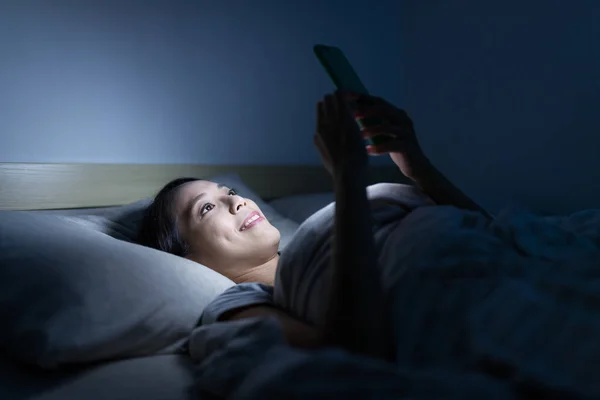 Mulher usando celular à noite — Fotografia de Stock