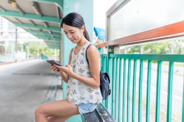 Cep telefonu ve bekleyen arkadaşlar kullanan kadın