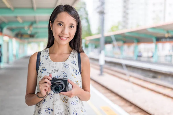 Mulher segurando câmera na estação ferroviária — Fotografia de Stock