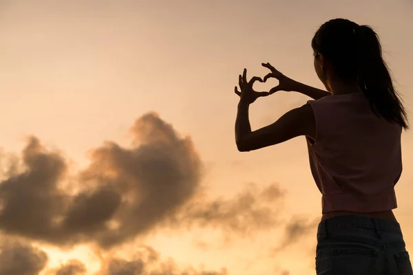 Donna che fa il simbolo del cuore con le mani — Foto Stock