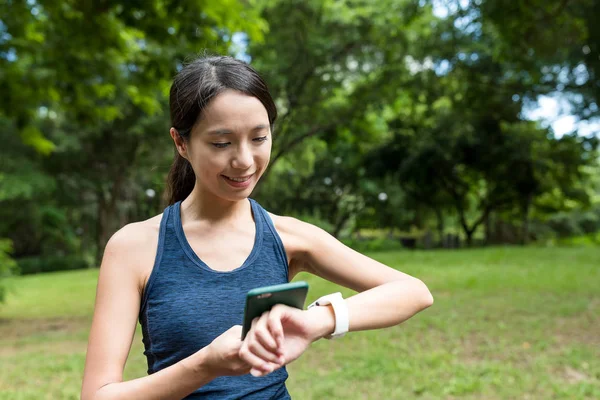 体育女人使用智能手表连接到手机 — 图库照片