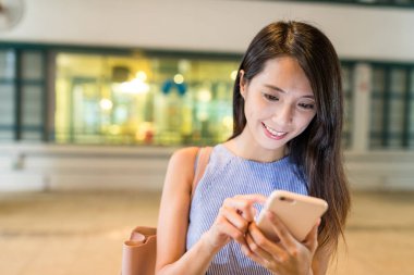 Alışveriş merkezinde cep telefonu kullanan kadın