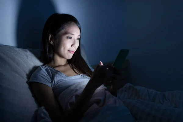 Mujer usando celular en la cama —  Fotos de Stock