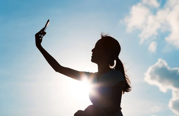 Silueta ženy, přičemž selfie s telefonem — Stock fotografie