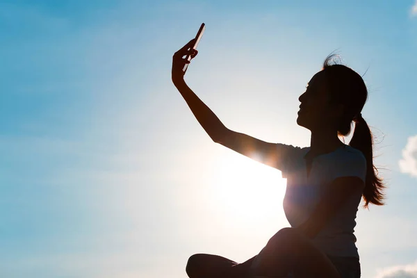 Silueta ženy, přičemž selfie s mobil — Stock fotografie