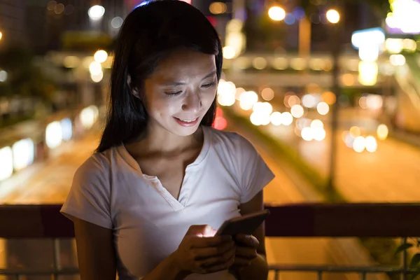 Mulher usando telefone celular à noite — Fotografia de Stock