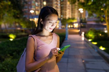 Cep telefonu parkta izlerken kadın