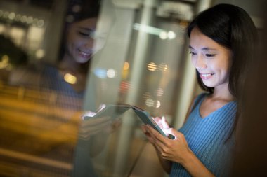 Geceleri cep telefonu kullanan bir kadın.