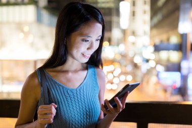 Geceleri cep telefonu kullanan kadın