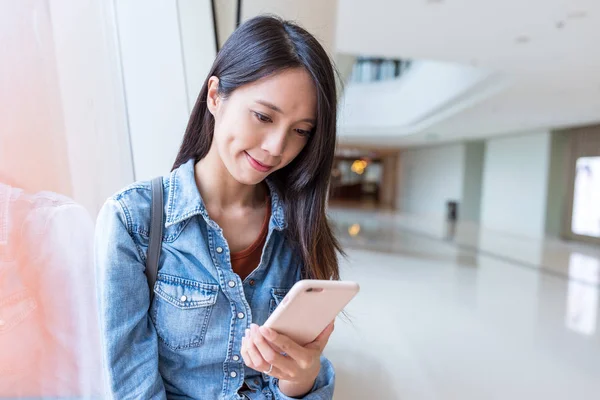 Vrouw met behulp van smartphone in het winkelcentrum — Stockfoto