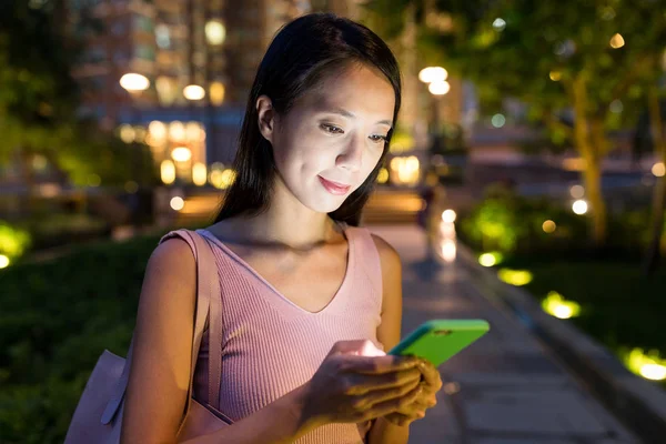 Smartphone şehirde geceleri kullanan kadın