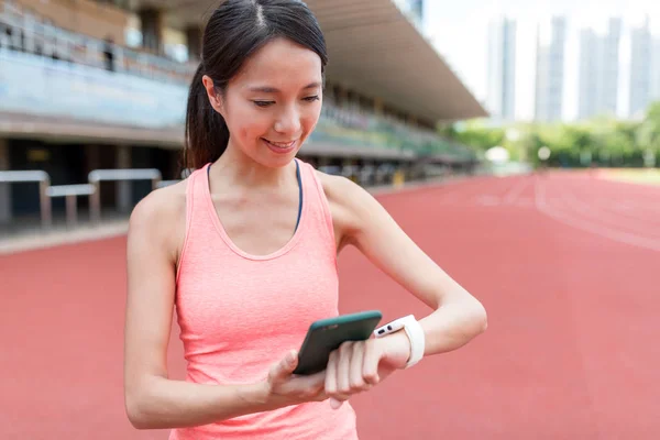 Sport kvinna med hjälp av mobiltelefon och ansluta smart Watch-klocka — Stockfoto